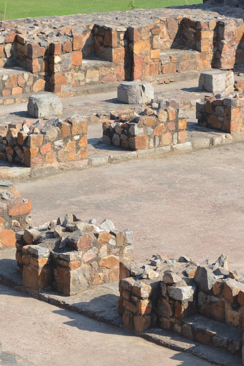 Stone ruins of ancient Firoz Shah Kotla fort in Delhi on a bright day.